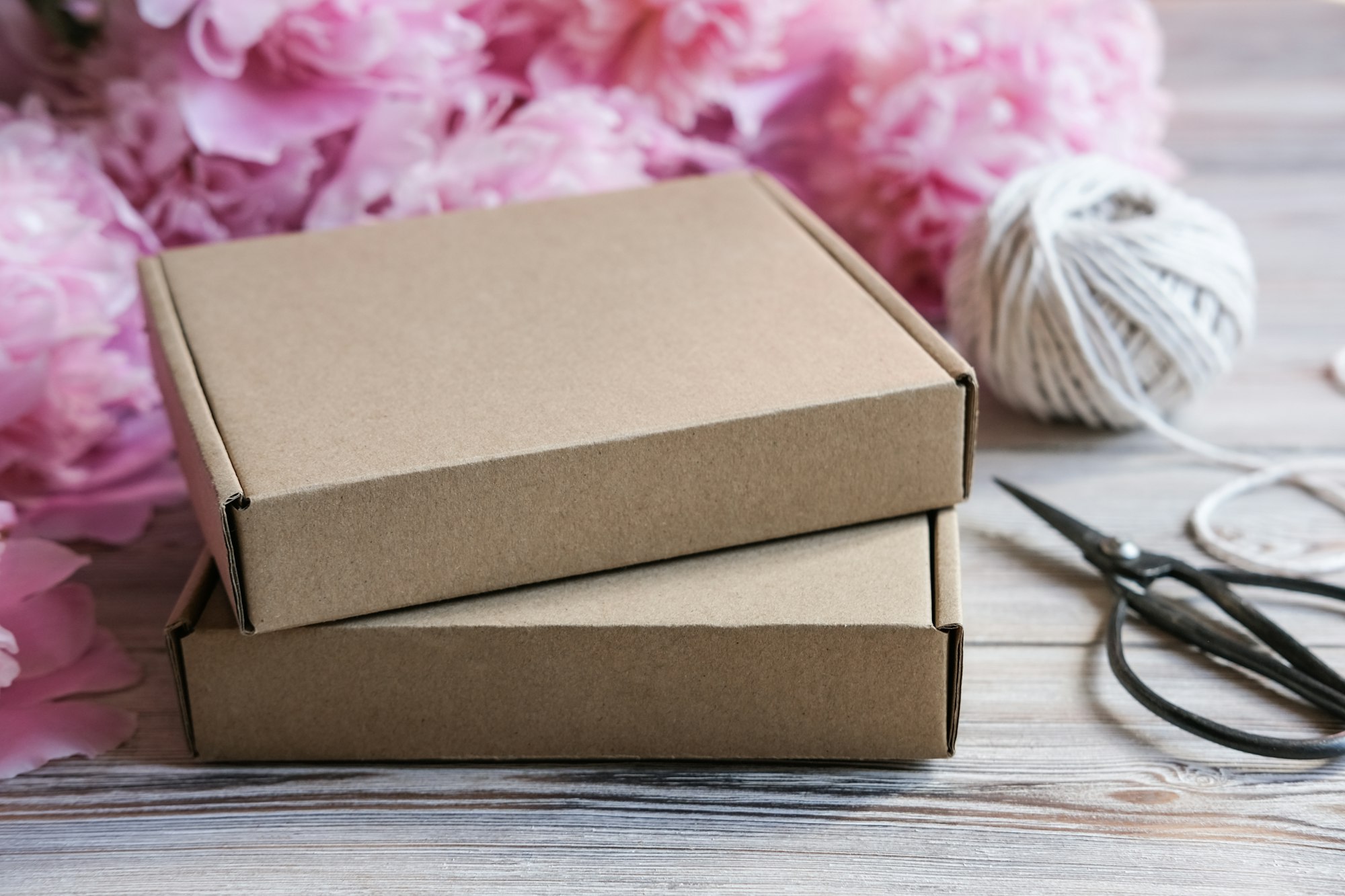 Brown cardboard boxes and peony flowers. Package box for branding. Mock up gift boxes