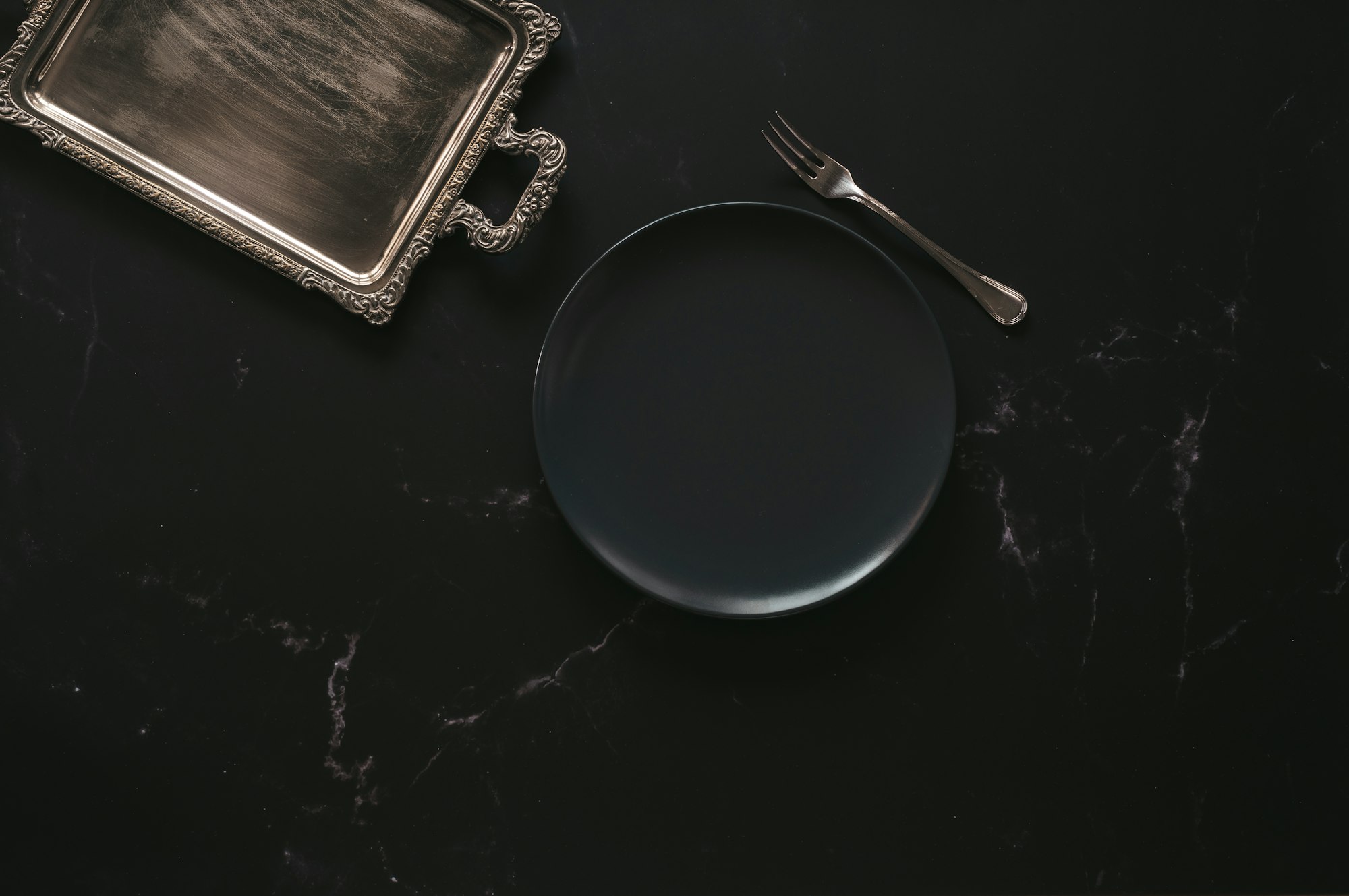 Empty plate with a silver tray and a fork